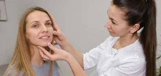 Female patient undergoing facial nerve exam by a clinician. illustrating Bell’s palsy assessment during pregnancy.