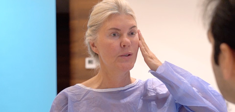 Female patient touching her face during pre-botox examination with doctor
