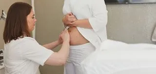 doctor checking tummy tuck patient