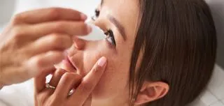 Woman applying eye drops for dry eye relief, illustrating home remedies and self-care tips for dry eye syndrome