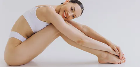 Smiling woman showing confidence and her body contour after a vertical thigh lift procedure