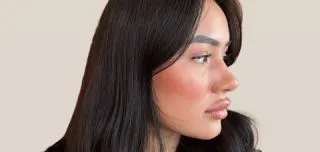 Side-profile photo of a woman with full, sculpted lips, illustrating the impact of choosing the right lip filler shape.