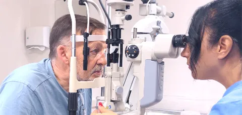 Ophthalmologist performing pre-op eye examination on male patient using slit lamp