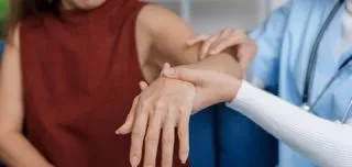 Doctor examining patient’s arm and wrist for signs of radial tunnel syndrome
