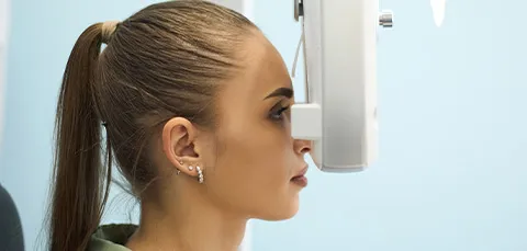 Woman receiving an eye exam to measure astigmatism before getting Toric IOL lens implants
