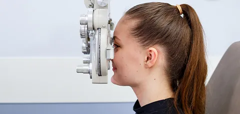 Young woman undergoing an eye exam to check for visual phenomena like halo effects after cataract surgery